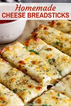 several slices of pizza on a cutting board next to a bowl of marinara sauce