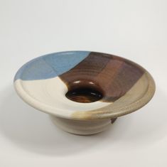 a ceramic bowl with an unusual design on the rim and bottom, sitting on a white surface