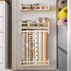 an organized kitchen cabinet with rolls of wrapping