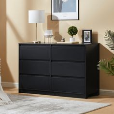 a black dresser with pictures on it in a living room