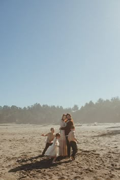 a group of people standing on top of a sandy beach