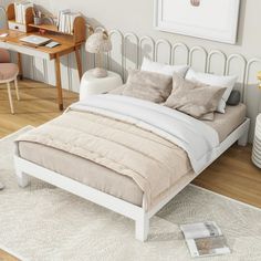 a white bed sitting on top of a wooden floor next to a desk and chair