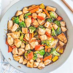 a pan filled with tofu, broccoli and carrots