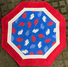 an umbrella with red, white and blue designs on it is laying on the ground