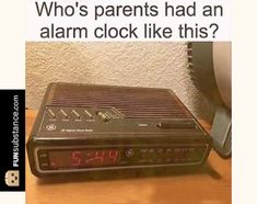 an alarm clock sitting on top of a wooden table next to a wall with the words, who's parents had an alarm clock like this? share if you had one