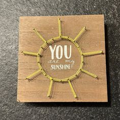 a wooden plaque with the words you are my sunshine written in white and yellow pins