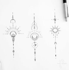 three different designs on a white paper next to a pen and ink drawing marker,