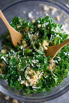 a glass bowl filled with greens and cheese