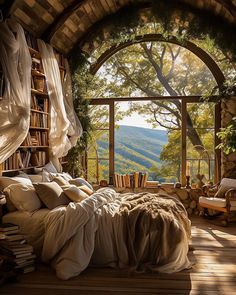 a bedroom with a large window and a bed in the middle of it, surrounded by bookshelves