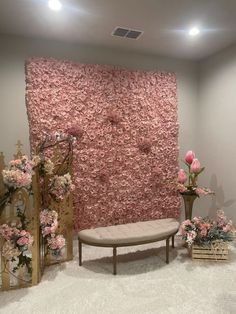 a room decorated with pink flowers and a wall made out of artificial rock, is shown in the foreground