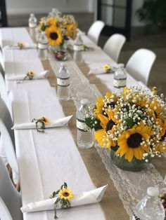 the table is set with sunflowers and baby's breath