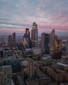 an aerial view of some very tall buildings in the city at sunset or sunrise time