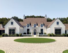 a large white house surrounded by lush green trees