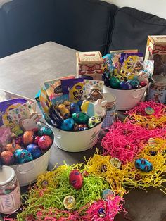 several buckets filled with easter eggs sitting on a table