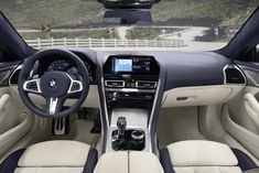 the interior of a bmw car with beige leather and black trims, including steering wheel