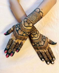 two hands with henna tattoos on them