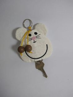 a keychain with a mouse on it hanging from the side of a wall