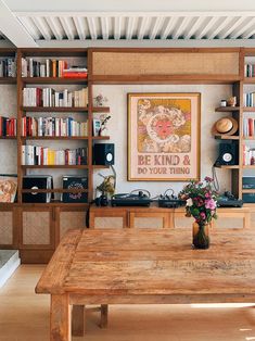 a wooden table sitting in front of a book shelf filled with books