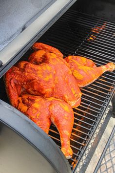 two chickens cooking on top of a bbq grill