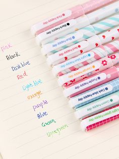 many different colored pens lined up on top of a notepad with the words pink, black, doublue, red, light blue, orange, purple, green, and white