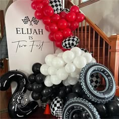 black and white balloons are on display in front of a sign