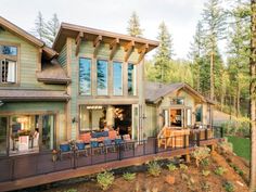 a large house sitting on top of a lush green hillside next to a forest filled with trees