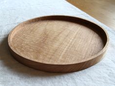 a wooden tray sitting on top of a white cloth covered table next to a wood floor