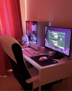 a desk with two computer monitors and a keyboard on it in front of a red curtain