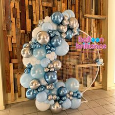 a bunch of balloons that are in the shape of a wreath with blue and silver balls