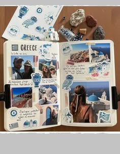 an open book with pictures and magnets on top of it, next to some rocks