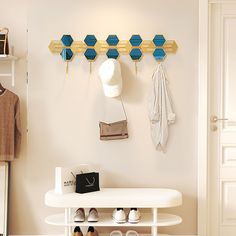 a coat rack with shoes and purses on it in a white entryway area