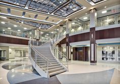 the inside of a large building with stairs and glass windows on the ceiling above it