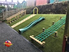 an artificial playground with a slide and climbing rope