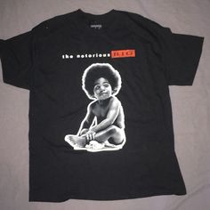 a black t - shirt with an image of a baby sitting on top of it