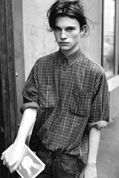 black and white photograph of a young man walking down the street with his hand in his pocket