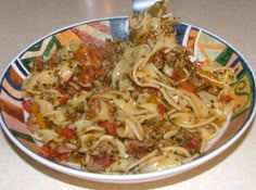 a bowl filled with pasta and meat on top of a table