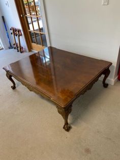 a large wooden table sitting in the middle of a living room next to a doorway