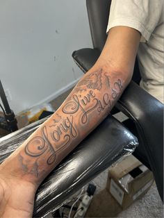 a person with a tattoo on their arm sitting in a chair