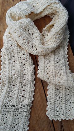 a white crocheted scarf sitting on top of a wooden table