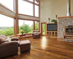 a living room filled with furniture and a fire place in front of a large window