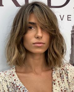 a close up of a person with long hair and a shirt on, looking at the camera