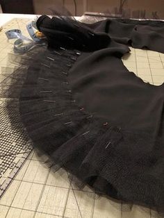 a black tutu skirt sitting on top of a table next to a pair of scissors