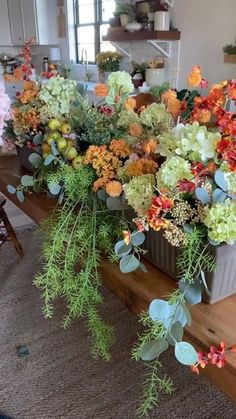 an arrangement of flowers on a table in a living room