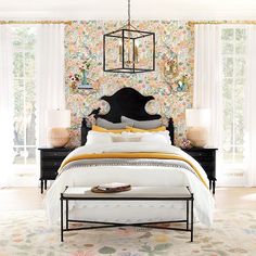 a bed room with a neatly made bed and a flowered wall paper on the walls