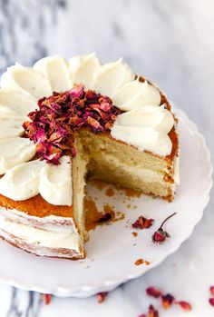 a cake with white frosting and pink flowers on top is cut in half to show the inside