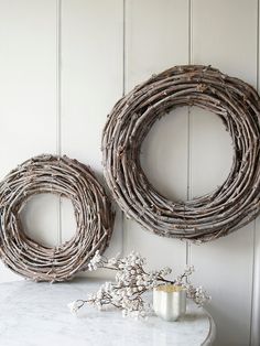 two wicker wreaths sitting next to each other on a table