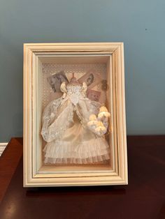 a doll in a shadow box on a table