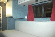 the interior of an rv with red curtains