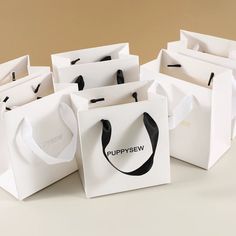 several white bags with black handles are stacked on top of each other and one is empty