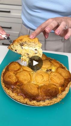 a person cutting into a pie on top of a blue countertop with a knife